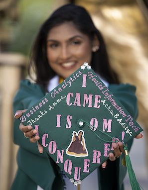 girl holding green decorated cap